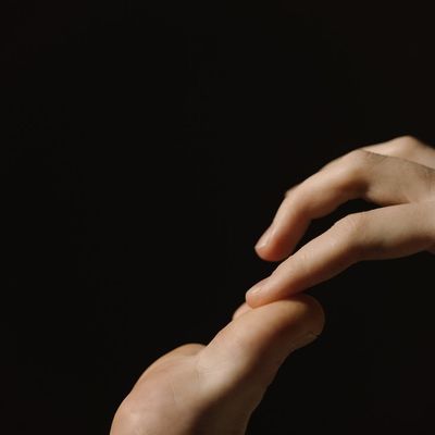 Close-up of a person's hands in a meditative gesture.
